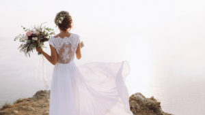 Bride overlooks cliff